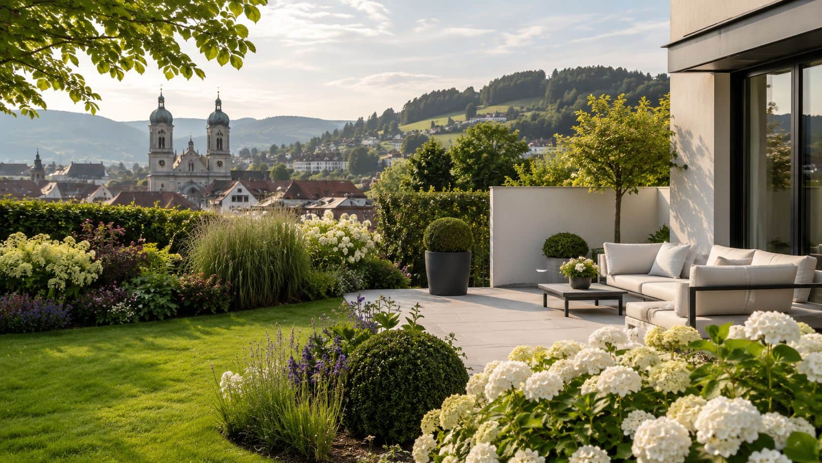 Eine luxuriöse Gartenterrasse mit Blick auf die Kathedrale von St. Gallen bei sonnigem Wetter.